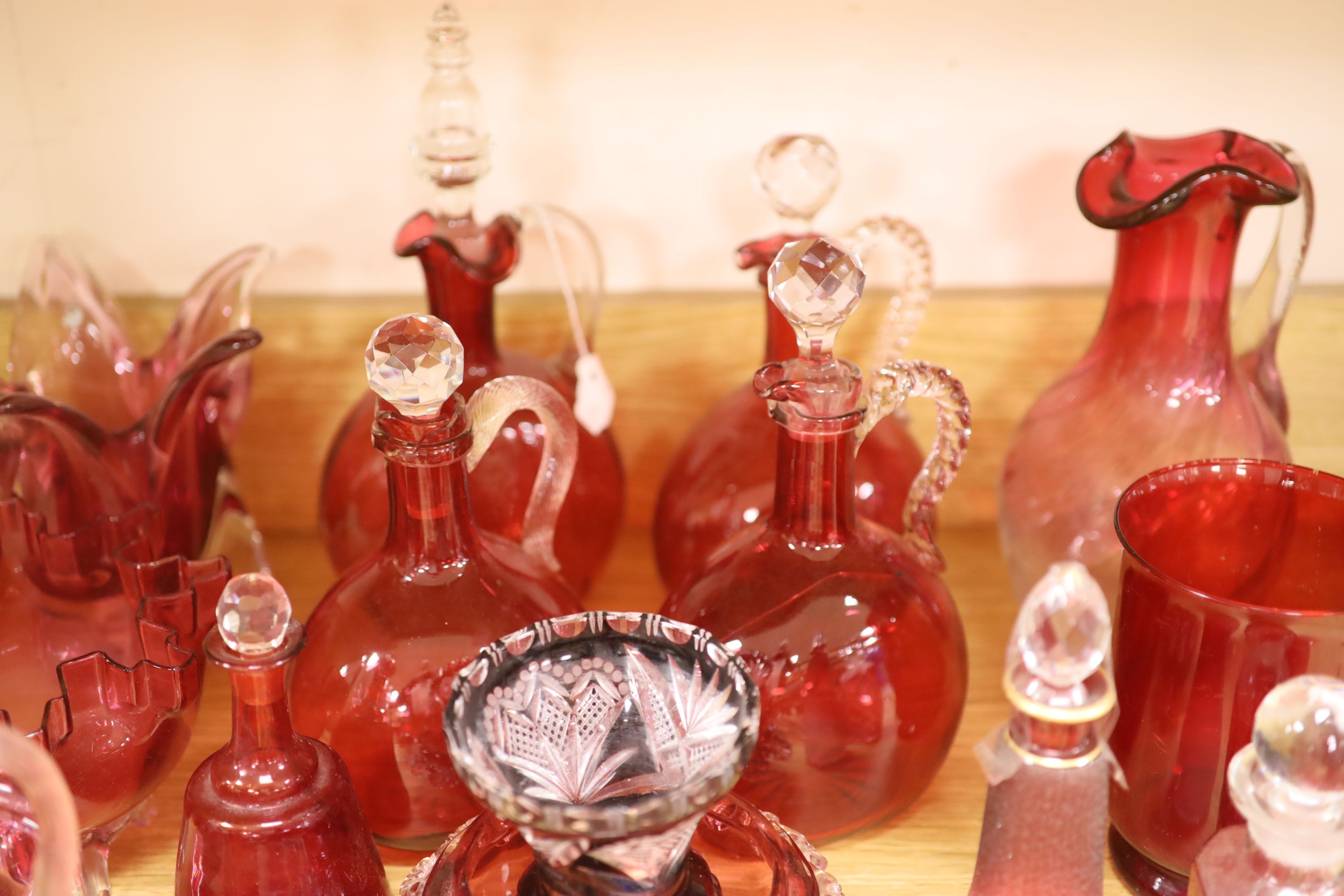 A large collection of cranberry glass